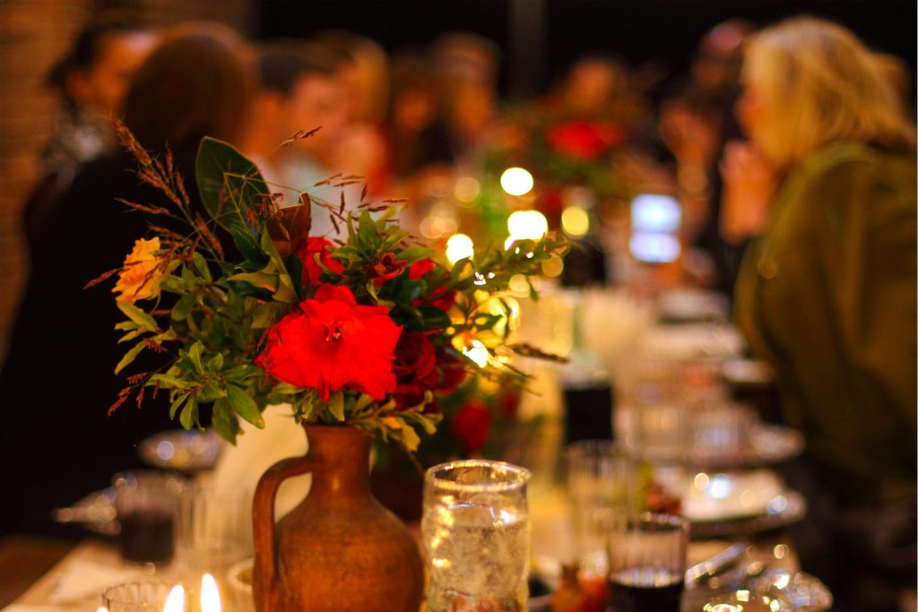 En röd blombukett på ett bord.